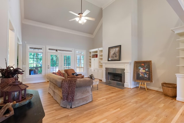 205 Saint Anne Way, Franklin, TN 37064 - living area with high vaulted ceiling, a tiled fireplace, ornamental molding, ceiling fan, and light wood-style flooring
