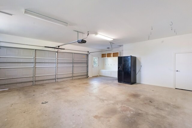 205 Saint Anne Way, Franklin, TN 37064 - garage with black refrigerator with ice dispenser and a garage door opener