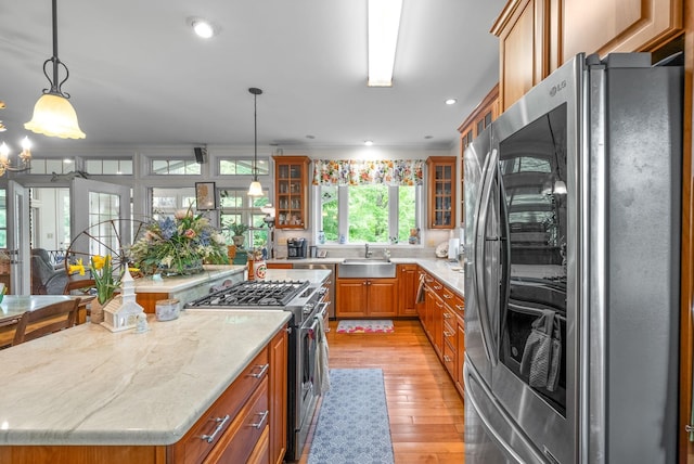 1711 Lovers Ln, Hopkinsville, KY 42240 - kitchen with stainless steel appliances, brown cabinetry, a kitchen island, a sink, and light wood-style floors