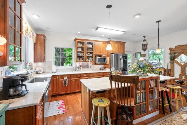 1711 Lovers Ln, Hopkinsville, KY 42240 - kitchen with stainless steel appliances, a sink, brown cabinets, plenty of natural light, and ornamental molding