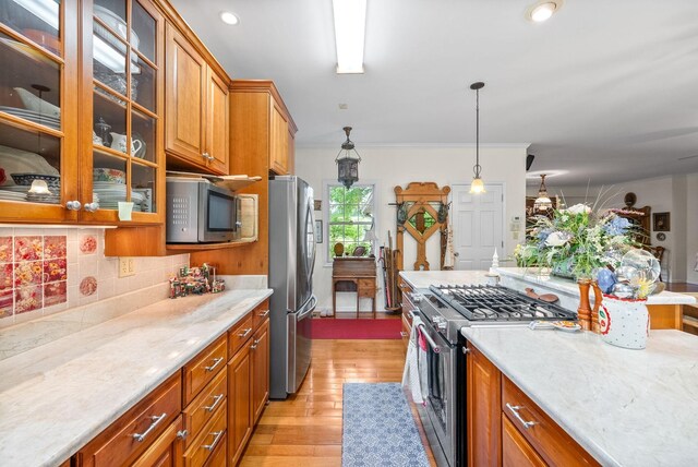 1711 Lovers Ln, Hopkinsville, KY 42240 - kitchen with appliances with stainless steel finishes, light wood-style flooring, brown cabinets, backsplash, and crown molding