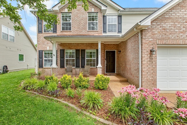 3182 Tristan Dr, Franklin, TN 37064 - view of front of house featuring a porch, a front yard, an attached garage, and brick siding