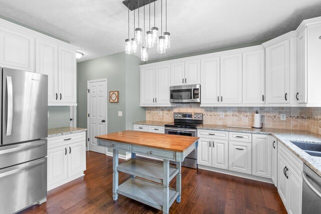 3182 Tristan Dr, Franklin, TN 37064 - kitchen featuring stainless steel appliances, decorative backsplash, dark wood finished floors, and white cabinets