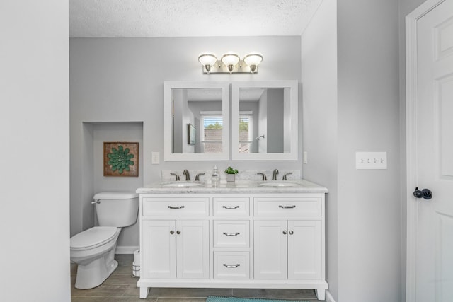 3182 Tristan Dr, Franklin, TN 37064 - bathroom with toilet, double vanity, a textured ceiling, baseboards, and wood finished floors