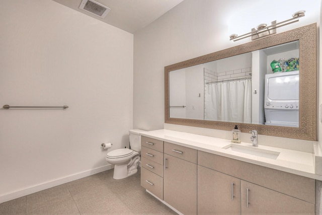 1900 12th Ave S Unit 406, Nashville, TN 37203 - full bathroom featuring estacked washer and dryer, vanity, toilet, baseboards, and curtained shower