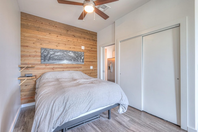 1900 12th Ave S Unit 406, Nashville, TN 37203 - bedroom with wood walls, wood finished floors, a closet, and a ceiling fan