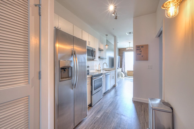 1900 12th Ave S Unit 406, Nashville, TN 37203 - kitchen with appliances with stainless steel finishes, wood finished floors, light countertops, a sink, and white cabinets