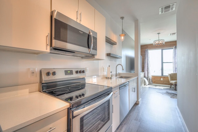 1900 12th Ave S Unit 406, Nashville, TN 37203 - kitchen with stainless steel appliances, a sink, light countertops, and pendant lighting