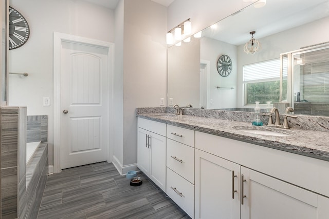 1717 Boardwalk Pl, Gallatin, TN 37066 - full bathroom featuring double vanity, a relaxing tiled tub, baseboards, a tile shower, and wood finished floors