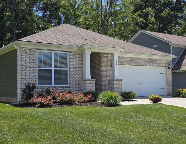 535 Ballard Dr, White House, TN 37188 - view of front of house with an attached garage, a front lawn, concrete driveway, a shingled roof, and brick siding