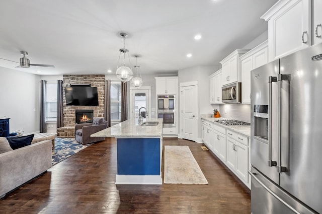 1151 Cotillion Dr, Murfreesboro, TN 37128 - kitchen featuring appliances with stainless steel finishes, open floor plan, a sink, a fireplace, and recessed lighting