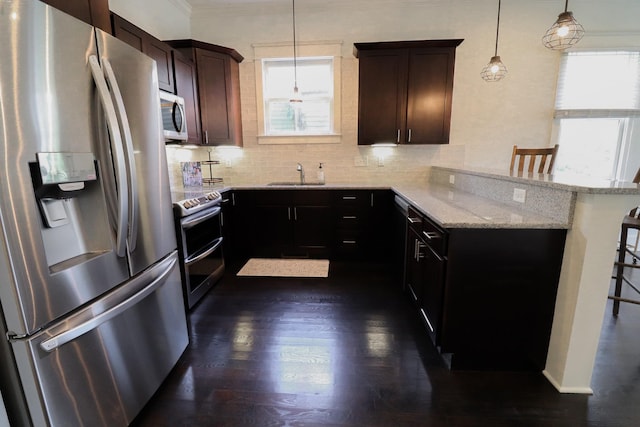 4802A Illinois Ave, Nashville, TN 37209 - kitchen featuring stainless steel appliances, a sink, a kitchen breakfast bar, a peninsula, and light stone counters