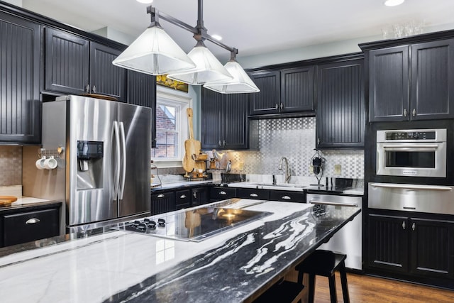 314 W 6th St Unit 7, Columbia, TN 38401 - kitchen featuring a warming drawer, stainless steel appliances, a sink, dark stone counters, and a breakfast bar area