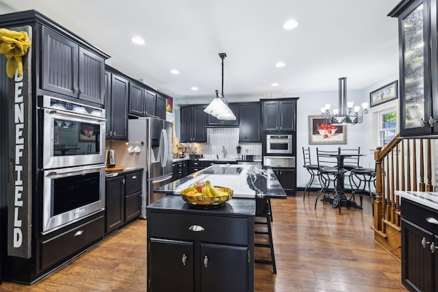 314 W 6th St Unit 7, Columbia, TN 38401 - kitchen with stainless steel appliances, dark cabinetry, tasteful backsplash, recessed lighting, and a breakfast bar
