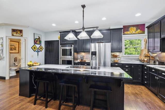 314 W 6th St Unit 7, Columbia, TN 38401 - kitchen with stainless steel appliances, a kitchen island, dark stone counters, tasteful backsplash, and wood finished floors