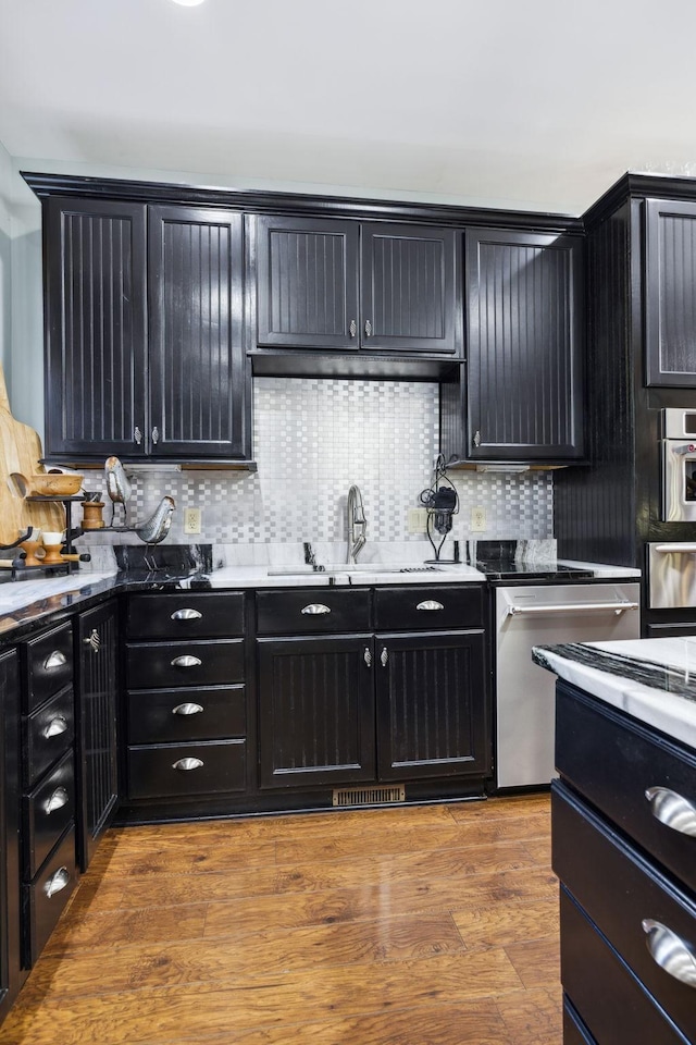 314 W 6th St Unit 7, Columbia, TN 38401 - kitchen featuring dishwasher, dark cabinetry, a warming drawer, a sink, and tasteful backsplash