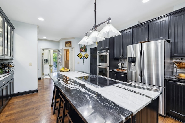 314 W 6th St Unit 7, Columbia, TN 38401 - kitchen with stainless steel appliances, a center island, light stone counters, a breakfast bar area, and dark wood finished floors