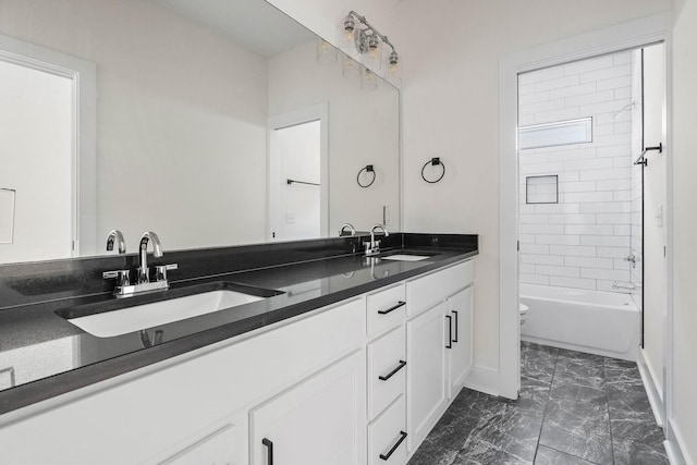 713B 32nd Ave N, Nashville, TN 37209 - full bathroom featuring double vanity, marble look tiles, toilet, and baseboards