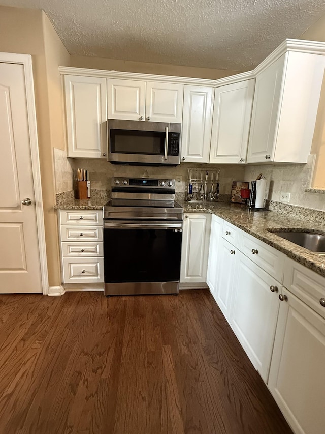 1602 Zurich Dr, Spring Hill, TN 37174 - kitchen with stainless steel appliances, dark wood-type flooring, white cabinetry, a textured ceiling, and stone counters