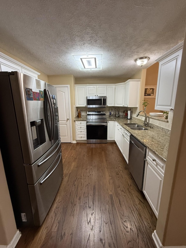 1602 Zurich Dr, Spring Hill, TN 37174 - kitchen featuring stainless steel appliances, a sink, dark wood-style flooring, white cabinetry, and light stone counters