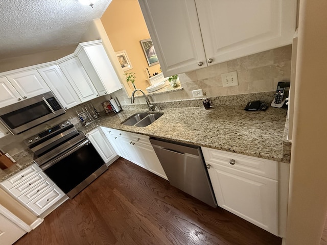 1602 Zurich Dr, Spring Hill, TN 37174 - kitchen featuring stainless steel appliances, a sink, dark wood finished floors, white cabinets, and a textured ceiling
