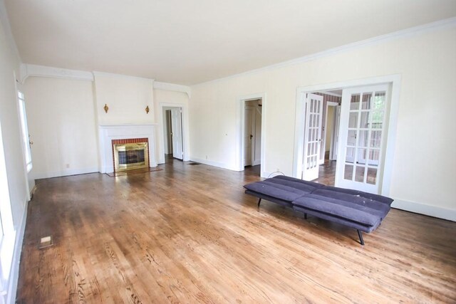 112 N Church St, Sparta, TN 38583 - unfurnished living room with french doors, ornamental molding, wood finished floors, a brick fireplace, and baseboards