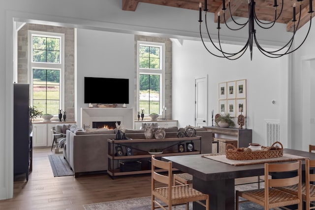 1936 Silver Fox Rd, Thompsons Station, TN 37179 - dining room featuring light wood-style floors, a warm lit fireplace, beamed ceiling, and a chandelier