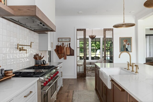 1936 Silver Fox Rd, Thompsons Station, TN 37179 - kitchen with wall chimney range hood, range with two ovens, a sink, dark wood-style floors, and light stone countertops