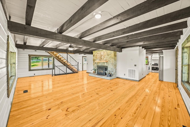4221 New Hope Rd, Celina, TN 38551 - unfurnished living room with a stone fireplace, beam ceiling, stairway, and wood-type flooring