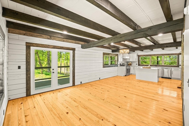 4221 New Hope Rd, Celina, TN 38551 - unfurnished living room featuring beamed ceiling, wood walls, a chandelier, french doors, and light wood-style floors
