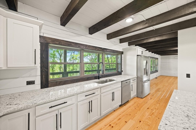4221 New Hope Rd, Celina, TN 38551 - kitchen featuring stainless steel appliances, a sink, white cabinetry, wood walls, and beam ceiling