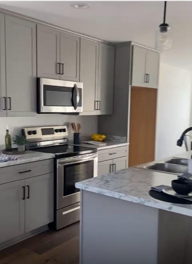 362 Baldwin Ln, Springfield, TN 37172 - kitchen featuring stainless steel appliances, gray cabinetry, a sink, dark wood-type flooring, and decorative light fixtures