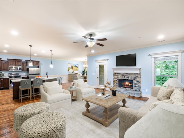1116 Rivercrest Dr, Murfreesboro, TN 37129 - living area featuring crown molding, a ceiling fan, light wood-style flooring, a fireplace, and baseboards
