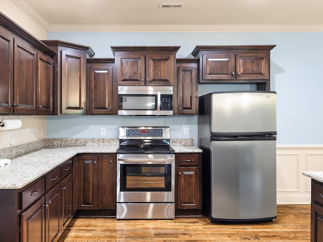1116 Rivercrest Dr, Murfreesboro, TN 37129 - kitchen featuring appliances with stainless steel finishes, dark brown cabinets, crown molding, light wood-type flooring, and a wainscoted wall