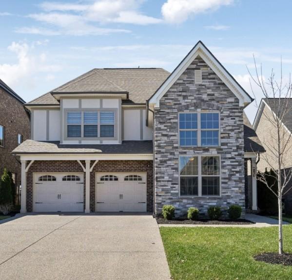 4337 Peacemill Ln, Murfreesboro, TN 37128 - view of front of house with concrete driveway, a garage, a front lawn, a shingled roof, and stone siding