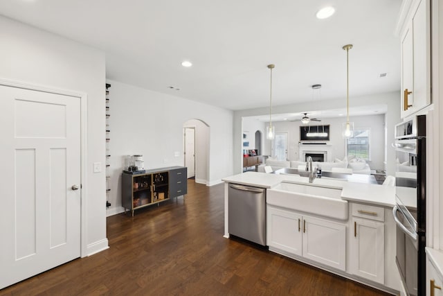 4337 Peacemill Ln, Murfreesboro, TN 37128 - kitchen featuring stainless steel appliances, arched walkways, a sink, open floor plan, and a fireplace