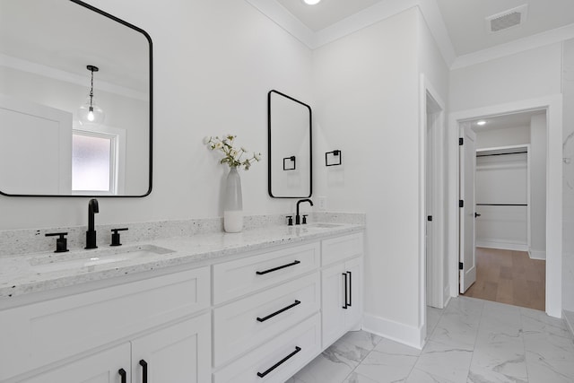 199 Beach Rd N, Killen, AL 35645 - bathroom with ornamental molding, double vanity, marble finish floors, a walk in closet, and baseboards