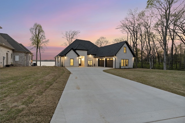 199 Beach Rd N, Killen, AL 35645 - french country home featuring a garage, concrete driveway, a lawn, and roof with shingles
