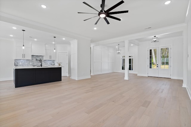199 Beach Rd N, Killen, AL 35645 - unfurnished living room featuring crown molding, a chandelier, ceiling fan, a sink, and light wood-style flooring