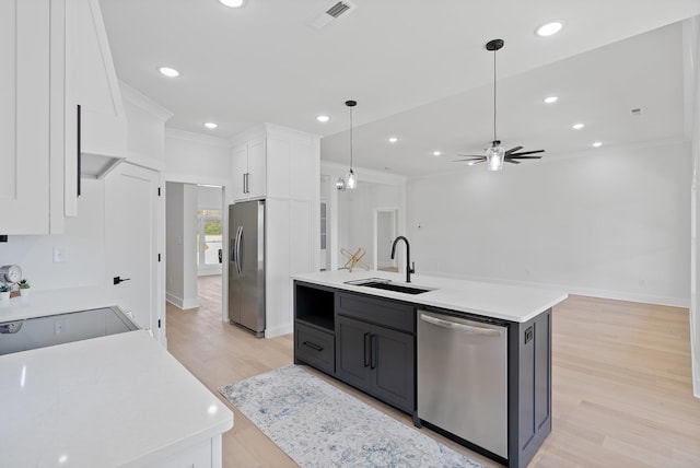 199 Beach Rd N, Killen, AL 35645 - kitchen featuring appliances with stainless steel finishes, a sink, white cabinetry, light wood finished floors, and ornamental molding