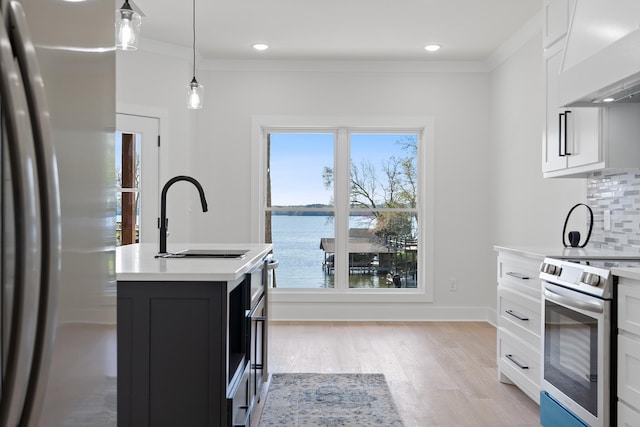 199 Beach Rd N, Killen, AL 35645 - kitchen with stainless steel appliances, wall chimney range hood, light countertops, tasteful backsplash, and white cabinets