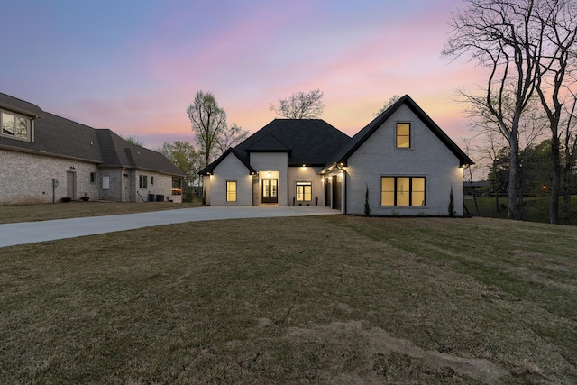 199 Beach Rd N, Killen, AL 35645 - french country style house featuring concrete driveway, a front lawn, and brick siding