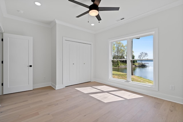 199 Beach Rd N, Killen, AL 35645 - unfurnished bedroom with a water view, light wood finished floors, baseboards, crown molding, and a closet