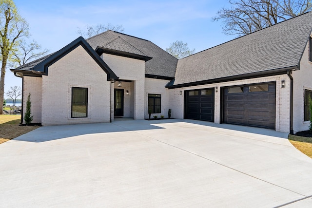 199 Beach Rd N, Killen, AL 35645 - french country home featuring brick siding, concrete driveway, a shingled roof, and an attached garage
