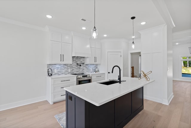 199 Beach Rd N, Killen, AL 35645 - kitchen featuring a sink, custom range hood, stainless steel range with electric cooktop, light wood-style floors, and tasteful backsplash