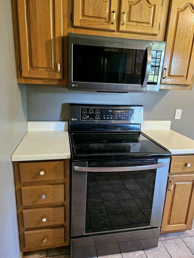 102 Hazelnut Ave, Camden, TN 38320 - kitchen featuring appliances with stainless steel finishes, light countertops, and brown cabinetry
