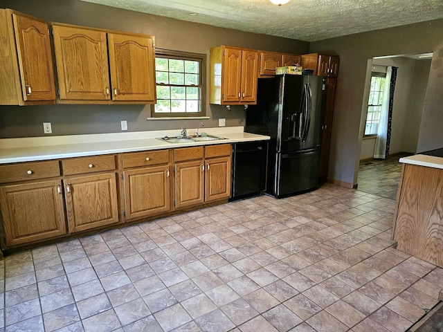 102 Hazelnut Ave, Camden, TN 38320 - kitchen with black appliances, a sink, light countertops, brown cabinetry, and a textured ceiling