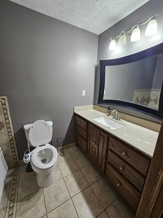 102 Hazelnut Ave, Camden, TN 38320 - bathroom featuring vanity, toilet, tile patterned floors, a textured ceiling, and baseboards