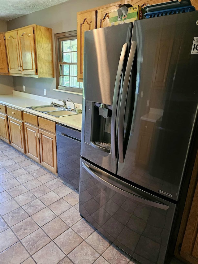 102 Hazelnut Ave, Camden, TN 38320 - kitchen with stainless steel fridge, dishwashing machine, light countertops, a sink, and light tile patterned floors