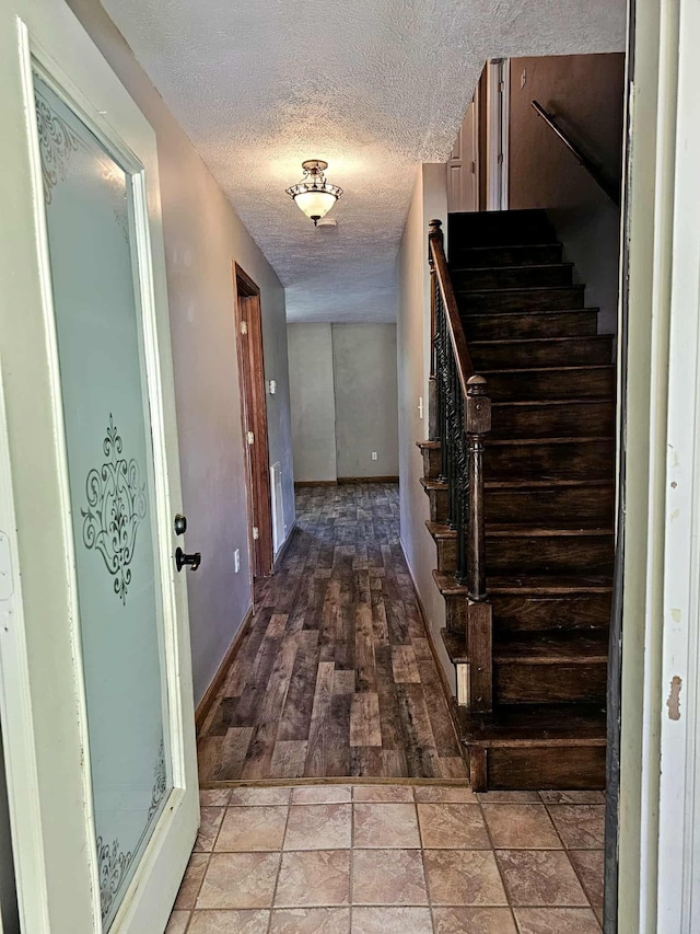 102 Hazelnut Ave, Camden, TN 38320 - staircase featuring a textured ceiling and baseboards